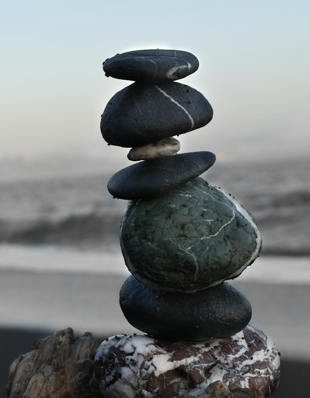 Smooth dark stones stacked on a beach