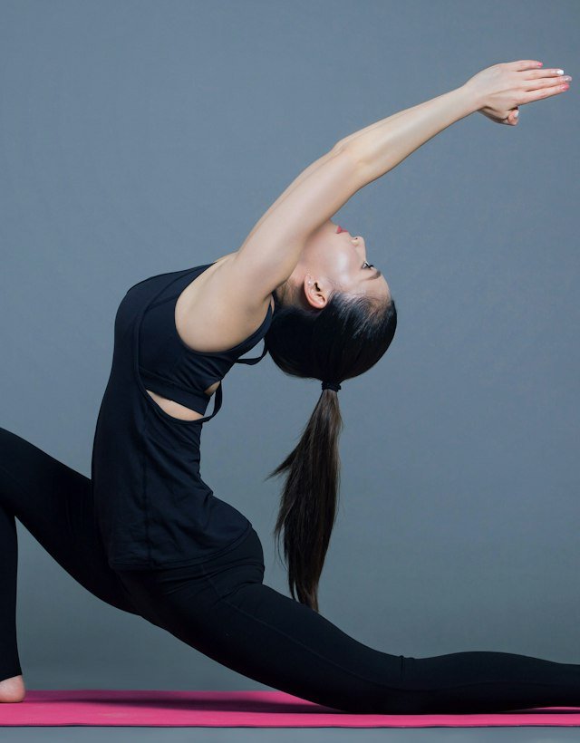 A woman in a low crescent lunge reaching back