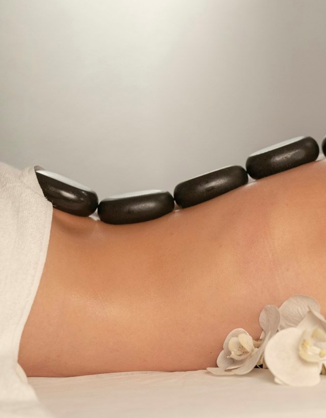 Warm stones laid along a person's back during a massage